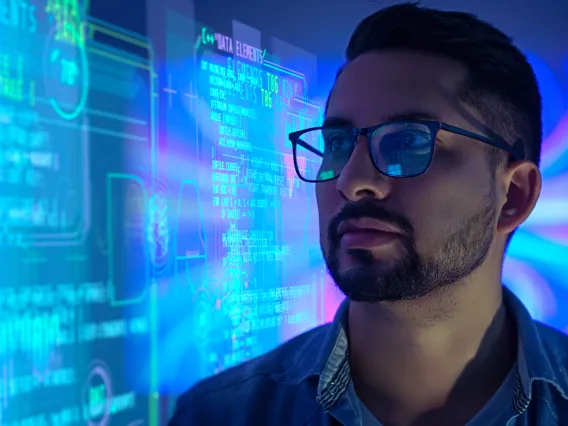 A person wearing glasses and looking at a display of data.