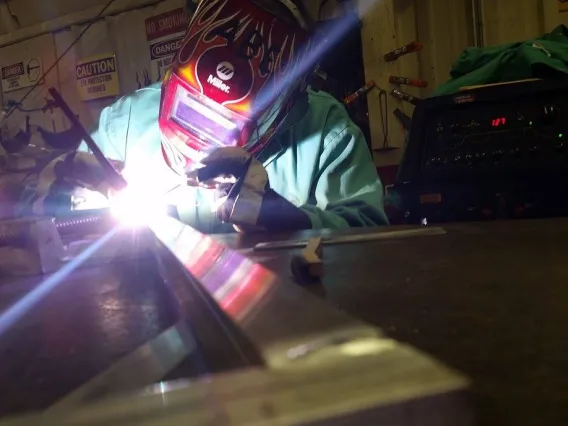 A student welding in the fabrication lab.