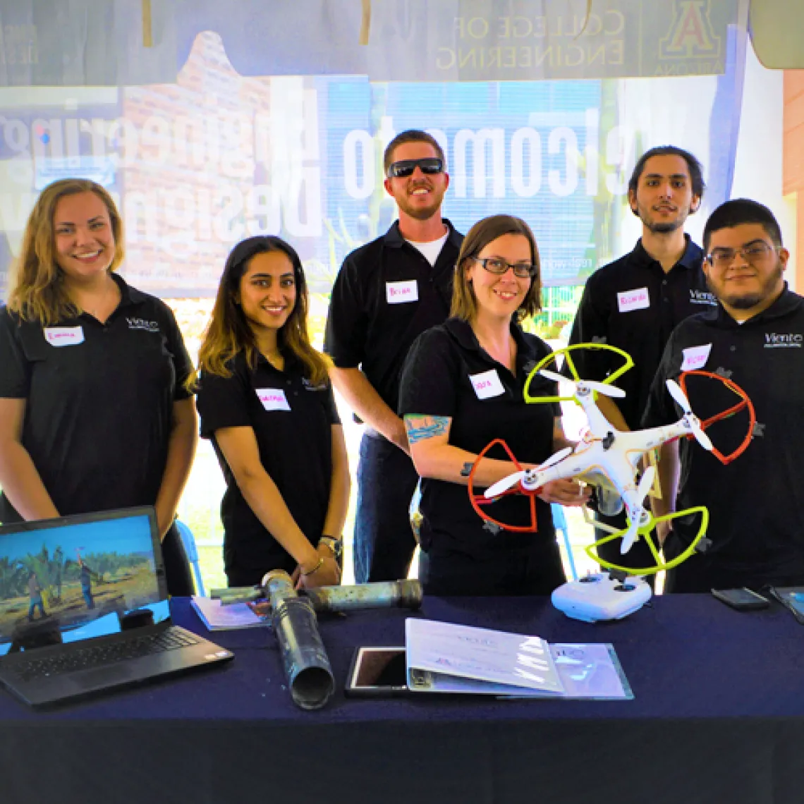 A group of students posing for a photo with a drone.