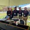 Photo of team members in front of table with engineering project.